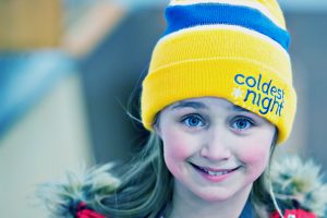 Little girl wearing yellow CNOY toque smiles for camera