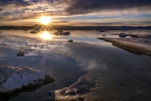 sunrise over a lakeshore with melting ice