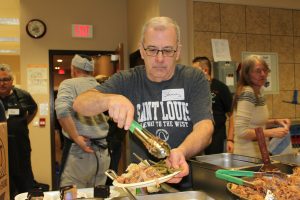 Volunteer serves a meal at the ROHCC