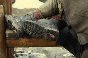 closeup of a homeless person's worn-out bootss