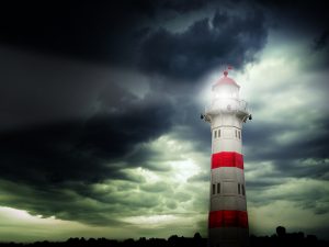 Lighthouse shining under a stormy sky