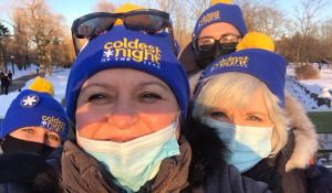 Four women wearing masks and blue toques