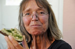 Smiling older woman enjoying a sandwich