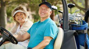 Smiling woman and man in golf cart