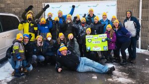 Group of teens wearing Coldest Night toques wave at the camera