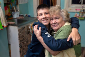 Teen boy hugs his grandmother