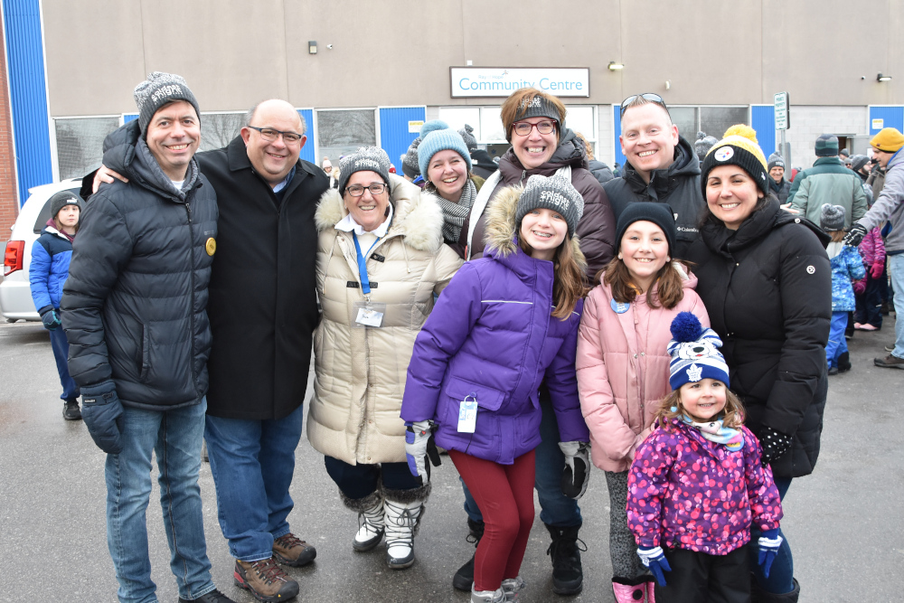Group of happy people wearing winter coats and toques