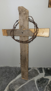 A wooden cross circled by a crown of barbed wire