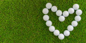 Golf balls on grass form the shape of a heart